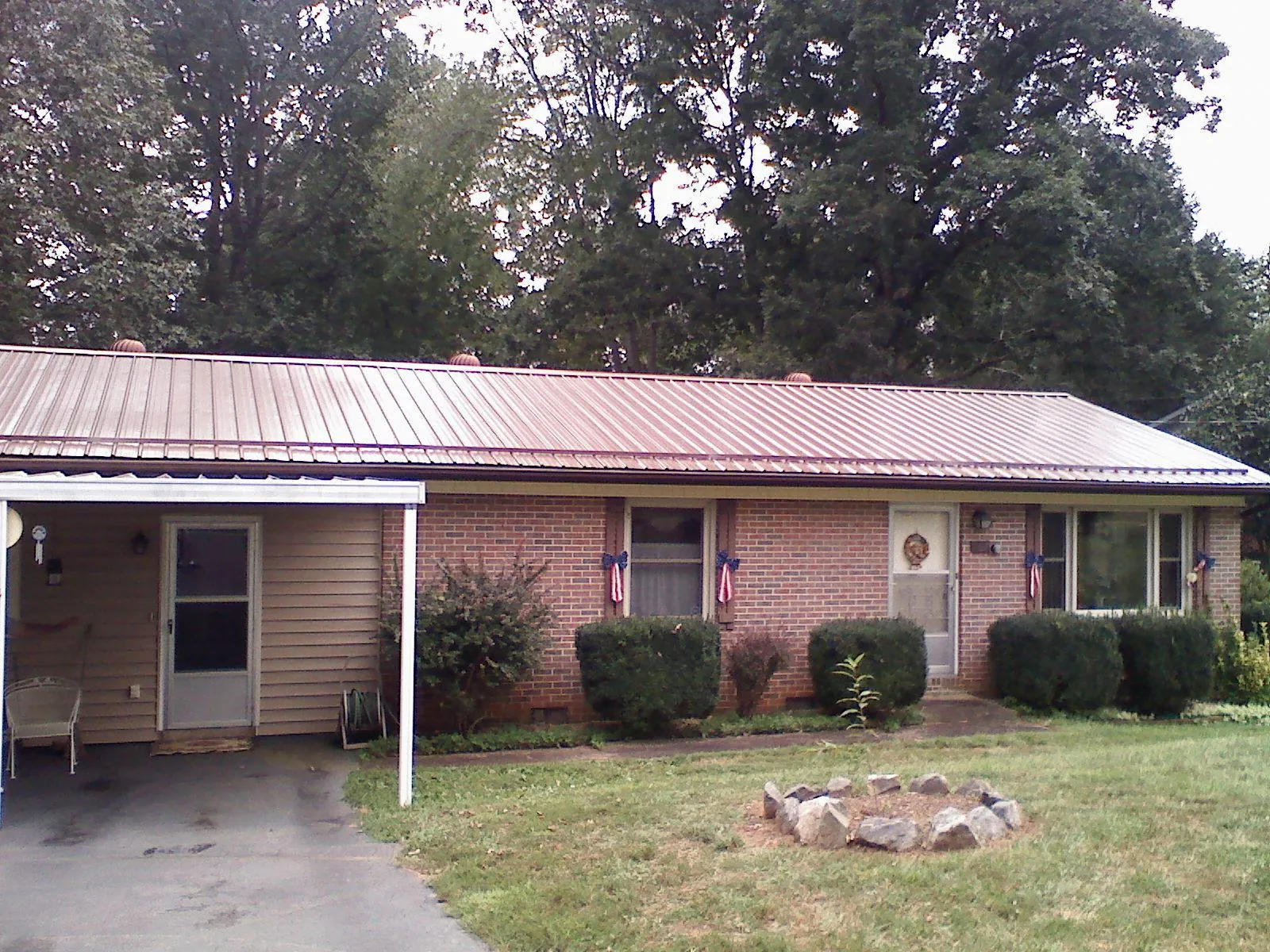 Bronze metal roof and carport on a brick ranch home — Roof Repair work by our crew in Lakehead