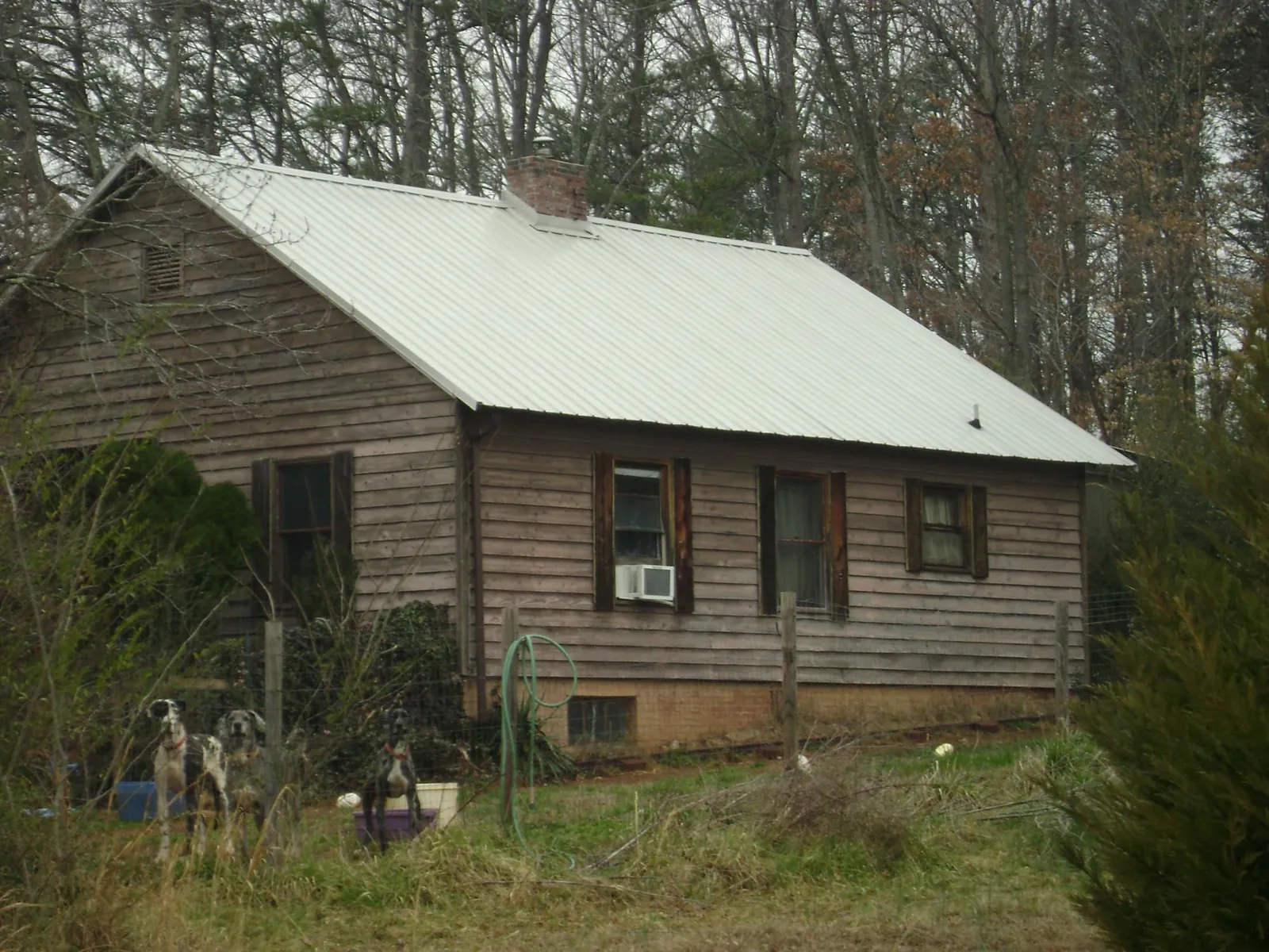 White metal roof on an old wood sided farmhouse, from a Metal Roof Installation job in Lakehead